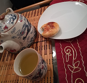 Chinese teapot, tea, and small cake